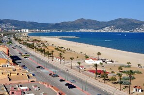 Eine Küstenstraße mit Strand und Bergen im Hintergrund.