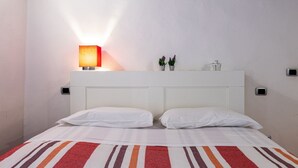 A hotel room with a bed, a nightstand, a lamp, and a small plant on the nightstand. - GuestHost - Cozy and colorful apartment of about 40 sqm, ideal for 2 people, located on the second floor of an ancient and characteristic building (NO lift). The property is located in the historic center of Florence (Restricted-Traffic Area), in the liv (Florence)