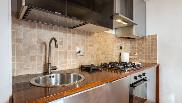 A kitchen with a stainless steel sink, a gas stove, and a built-in oven. - GuestHost - Cozy and colorful apartment of about 40 sqm, ideal for 2 people, located on the second floor of an ancient and characteristic building (NO lift). The property is located in the historic center of Florence (Restricted-Traffic Area), in the liv (Florence)