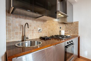 A kitchen with a stainless steel sink, a gas stove, and a built-in oven. - GuestHost - Cozy and colorful apartment of about 40 sqm, ideal for 2 people, located on the second floor of an ancient and characteristic building (NO lift). The property is located in the historic center of Florence (Restricted-Traffic Area), in the liv (Florence)