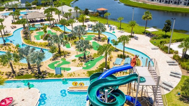 A water park with a large pool, a water slide, and a golf course.