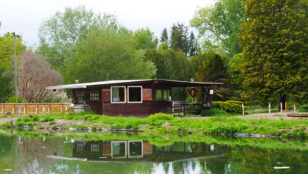 A cabin by a lake with a wooden deck and a small dock. - Bright 2-4 pers. loft with terrace and on-site restaurant (Lacroix-sur-Meuse)