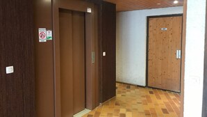 A hallway with wooden doors and a tiled floor. - Cozy studio for 4, balcony, in Samoëns (Samoëns)