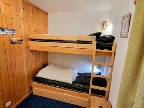 A bunk bed room with wooden walls and a blue floor.