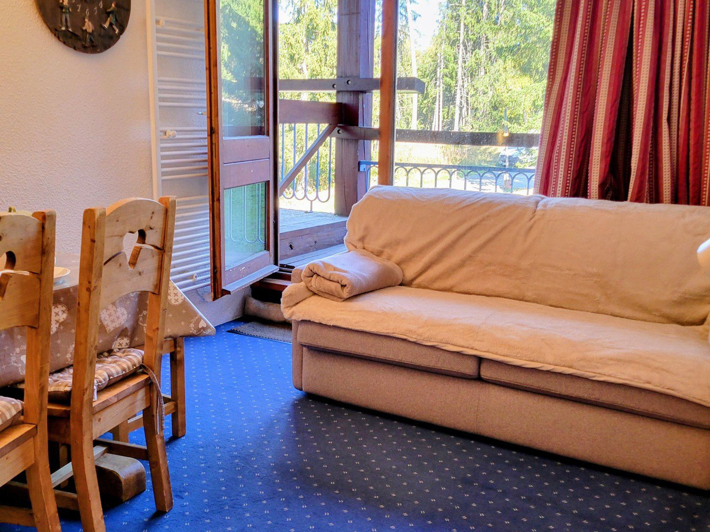Una habitación acogedora con un sofá, una silla de madera y una mesita.