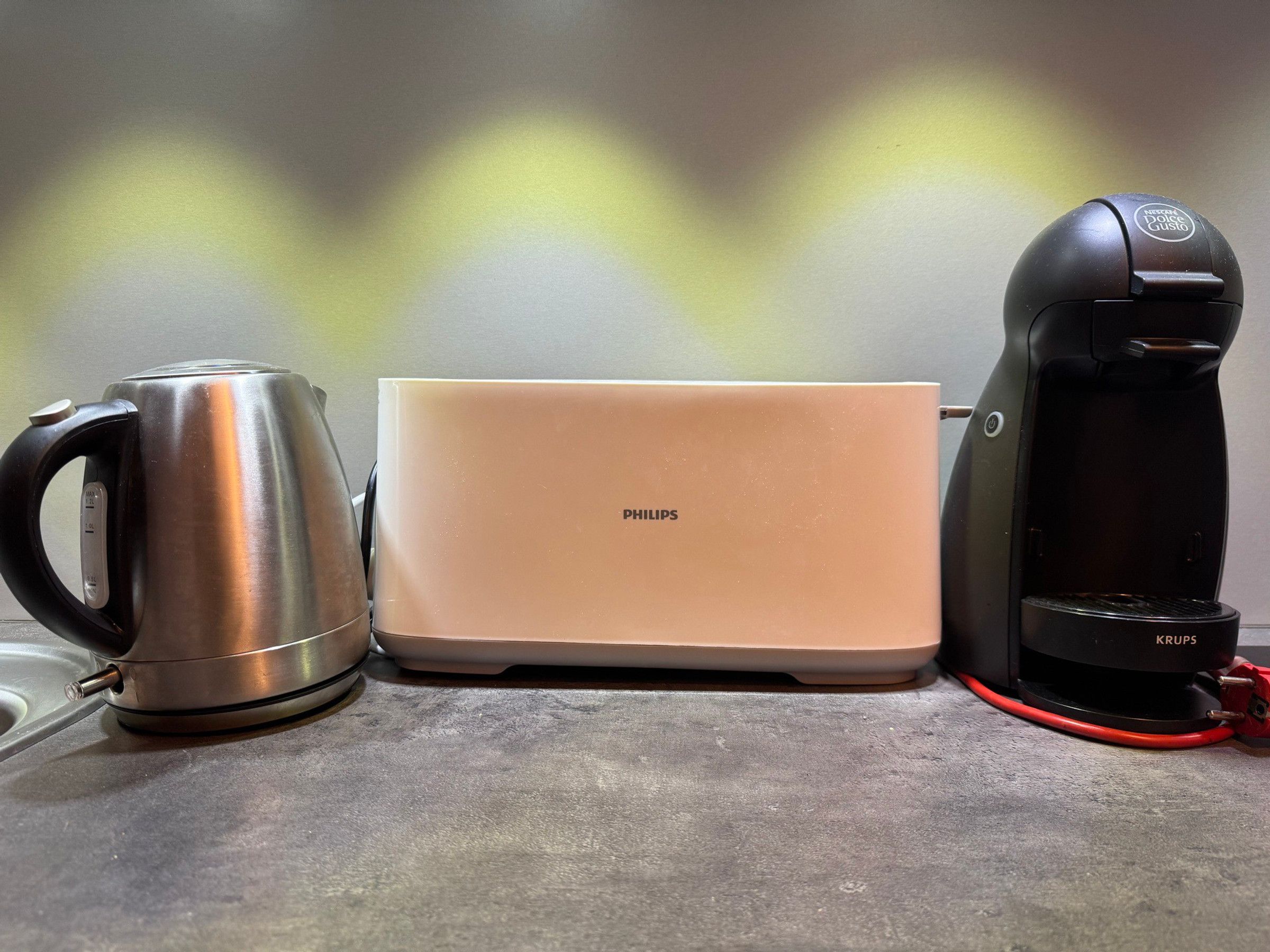 A coffee maker, a kettle, and a toaster on a countertop.
