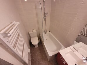 Ein Badezimmer mit Toilette, Badewanne und Dusche.