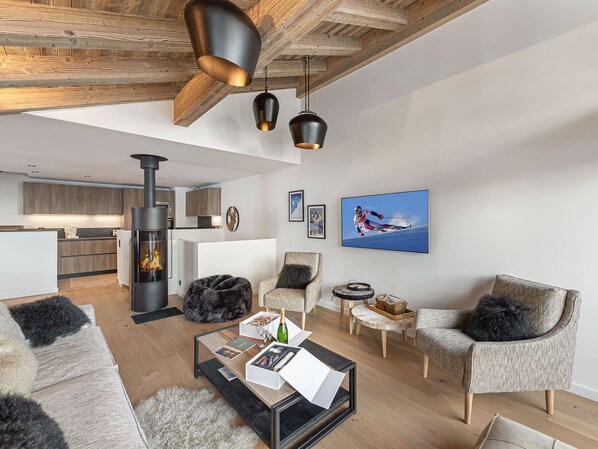 Uma sala de estar moderna com lareira, assentos confortáveis e uma obra de arte com tema de esqui.