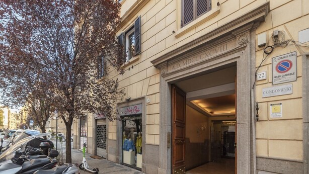 Una entrada de edificio con un letrero que dice 'A.D. MDCCCXCVI' y un letrero que indica 'CONDOMINIO'.