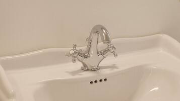 Un lavabo bianco con uno specchio rotondo sopra.