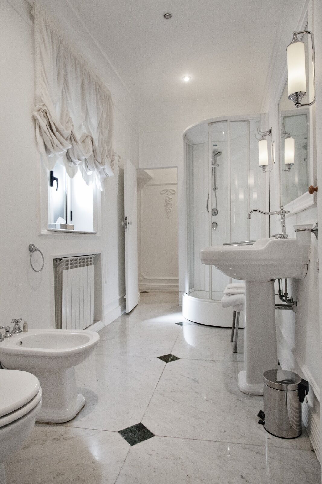 A modern bathroom with a bidet, a sink, and a shower.