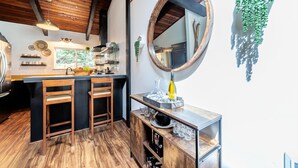 Cozinha moderna com detalhes em madeira, um espelho grande e um espaço bar com banquetas.