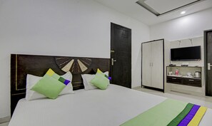 A hotel room with a large bed, a wardrobe, a television, and a bathroom.