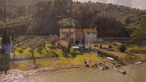 A riverside property with a large house, boats, and a lush green landscape. - Folaga Apartments, "Puntone" (Sant'Arcangelo)