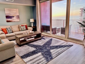 A living room with a sofa, coffee table, and a starfish rug.