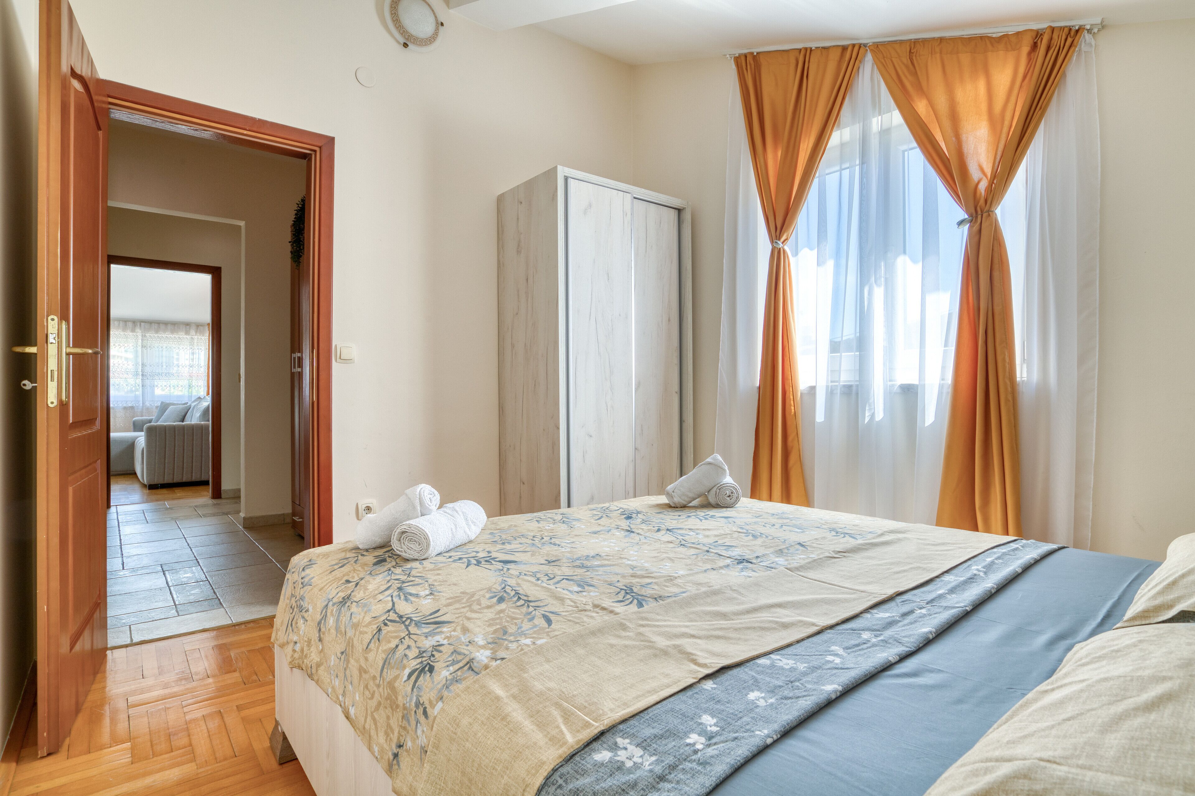 Een slaapkamer met een bed, een kledingkast en uitzicht op een gang.