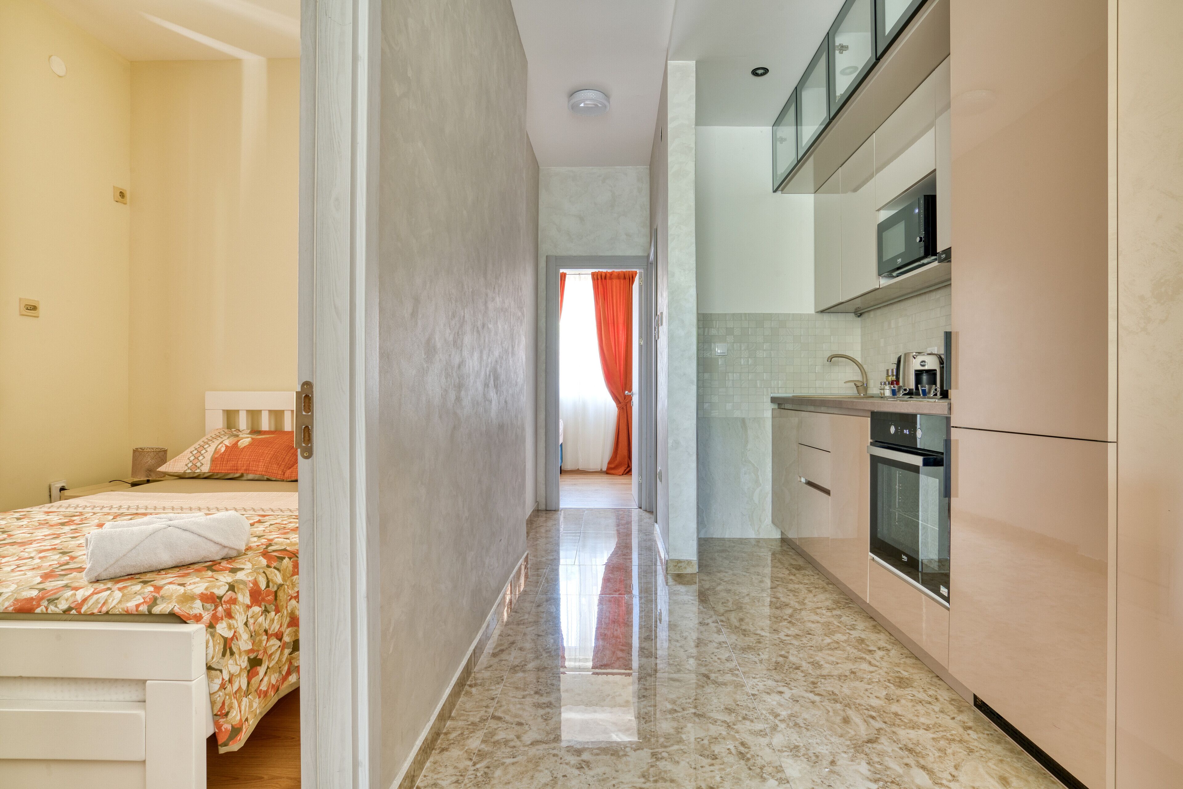 A hotel room with a bed, a bathroom, and a kitchenette.