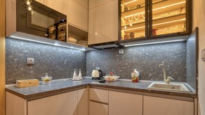 Eine moderne Küche mit Granit-Arbeitsplatten, einem Einbauofen und einer Edelstahl-Spüle.