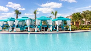 A poolside area with turquoise canopies and lounge chairs. - Margaritaville Townhome Retreat (Kissimmee)
