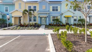 A row of colorful townhouses with a parking lot in front. - Margaritaville Townhome Retreat (Kissimmee)
