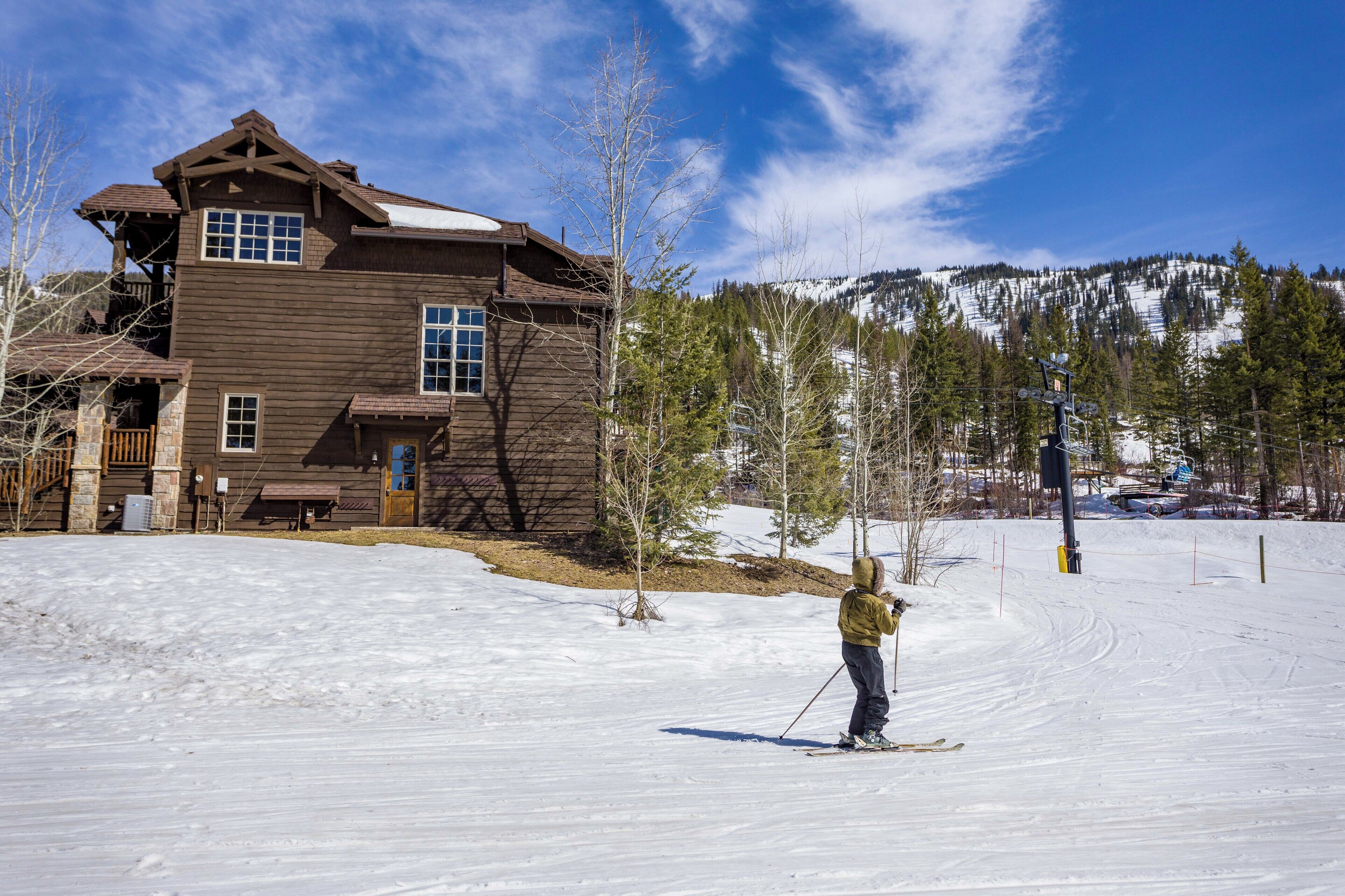 Une cabane en bois avec une piste de ski en arrière-plan.