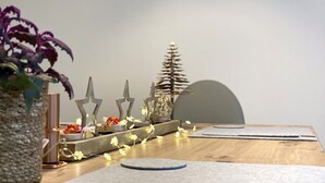 A wooden table with decorative items including a plant, star-shaped objects, and a spiral tree model. - Mein Apartment, Stars for 4 Person (Frankenthal)