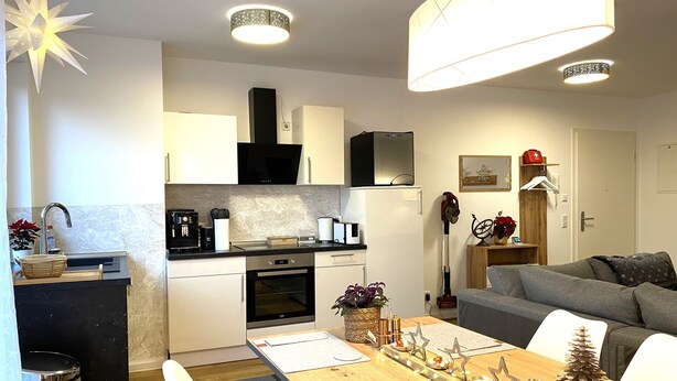 A modern kitchen with a dining area, a small living space, and a compact bathroom. - Mein Apartment, Stars for 4 Person (Frankenthal)