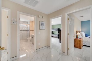 A hotel room with a bathroom, a bedroom, and a hallway. - 4BR | South Facing Pool | Close to Attractions (Kissimmee)