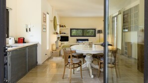 Een moderne keuken met een eethoek, met een ronde tafel, stoelen en een inbouwoven.