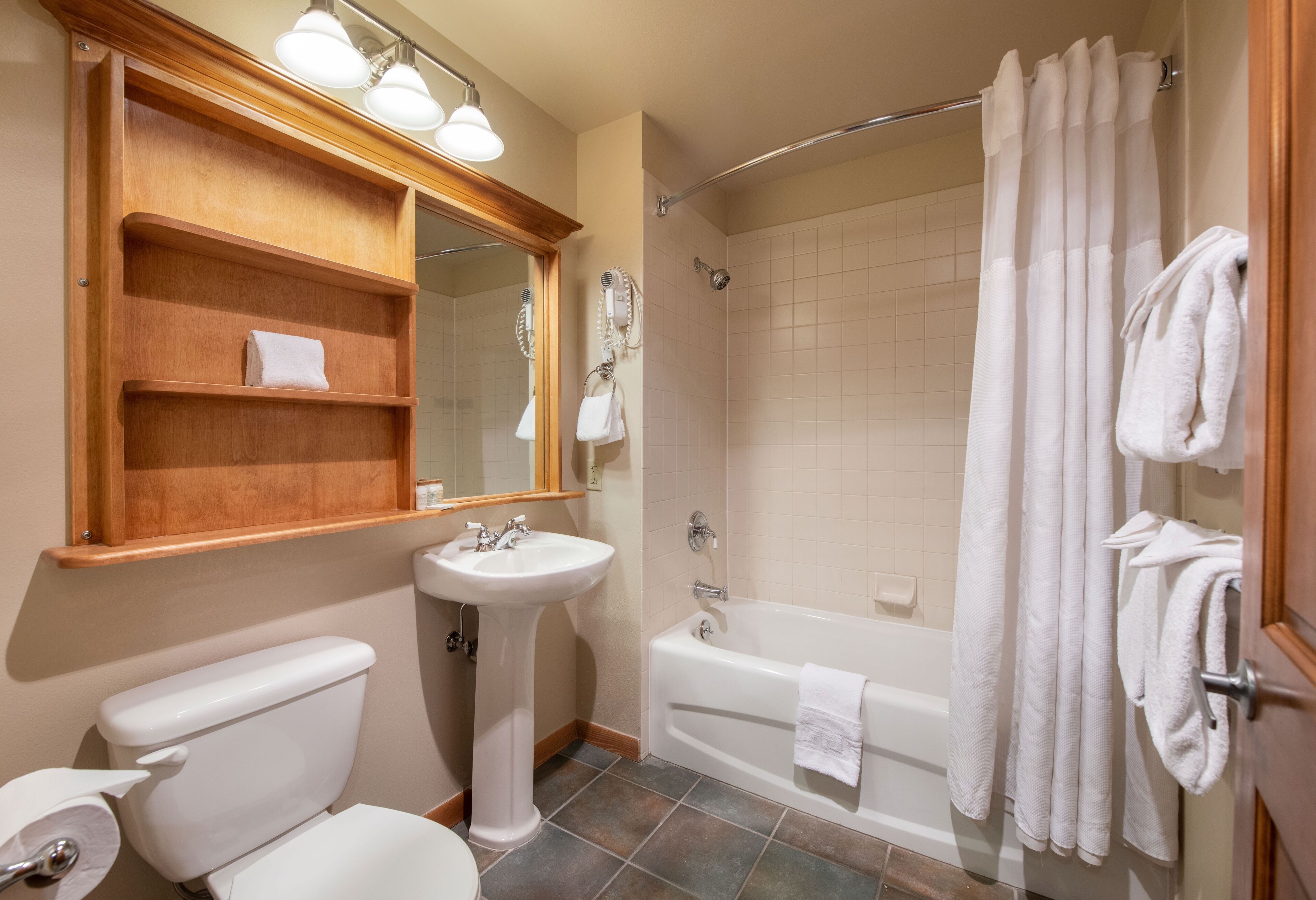 Une salle de bain comprenant des toilettes, un lavabo, une baignoire et une douche.