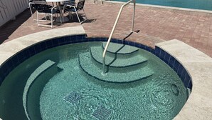 Una piscina cristalina con borde de azulejos y una escalera.