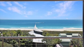 Un balcon avec vue sur une plage et l’océan.