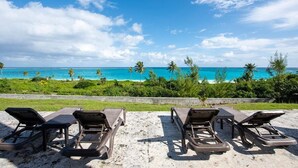 Une plage avec des chaises longues et une vue sur l’océan.