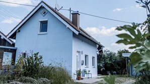 Une maison de plain-pied avec un toit en pente, une antenne parabolique et une petite fenêtre.