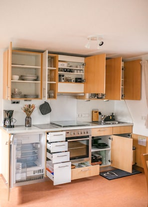 Een koelkast, een oven, een kookplaat, een koffiezetapparaat/waterkoker