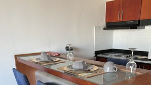 Una cocina moderna con una isla central, taburetes de bar y una mesa de comedor preparada para cuatro.