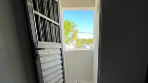 A narrow room with a sliding door leading to a balcony. - Pousada Mar do Sonho Praia (Ipojuca)