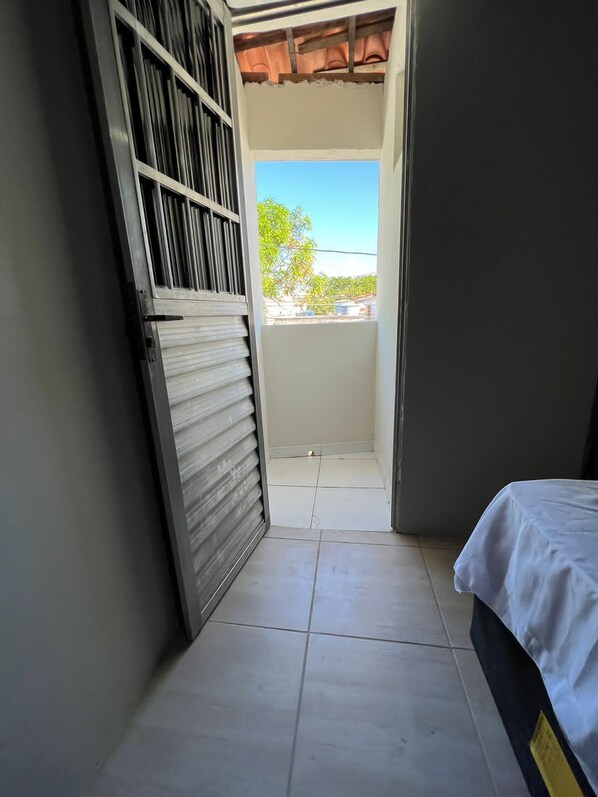 Una habitación estrecha con una puerta corrediza que da a un balcón.