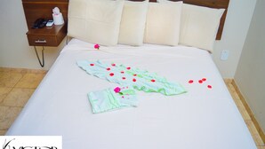A hotel room with a neatly made bed, a bedside table with a phone and a tissue box, and a wall socket. - Victor Hotel (Patos de Minas)