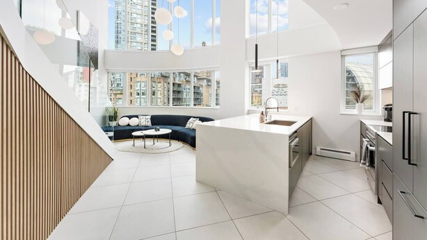 Een moderne keuken met een centraal eiland, grote ramen en een inbouwoven.