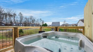 A hot tub on a balcony with a view of houses and trees. - Cozy Hideaway • Hot Tub • Arcade Machine • Dogs OK (Sevierville)