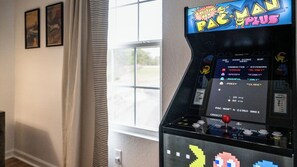 A Pac-Man arcade machine with a display screen, control buttons, and a joystick.