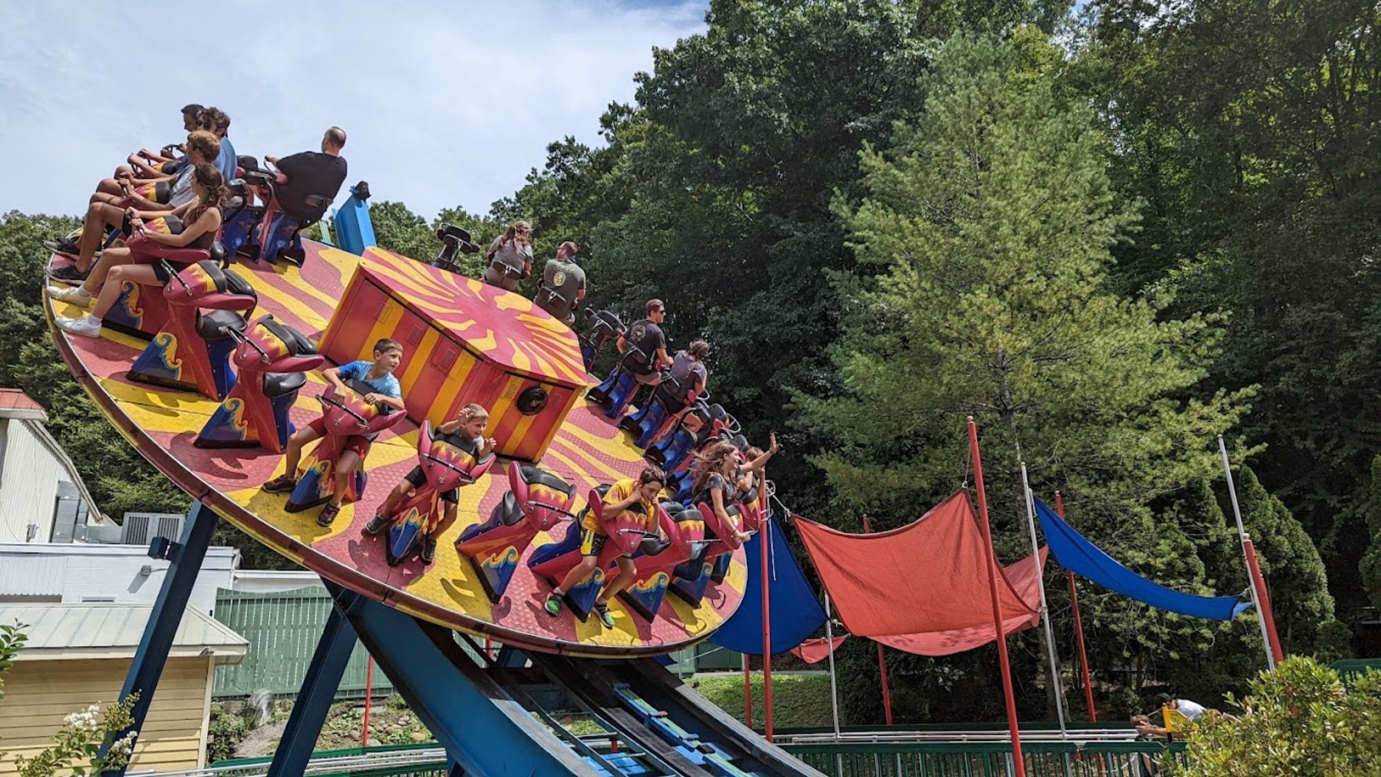 A colorful amusement ride with multiple seats and a track.
