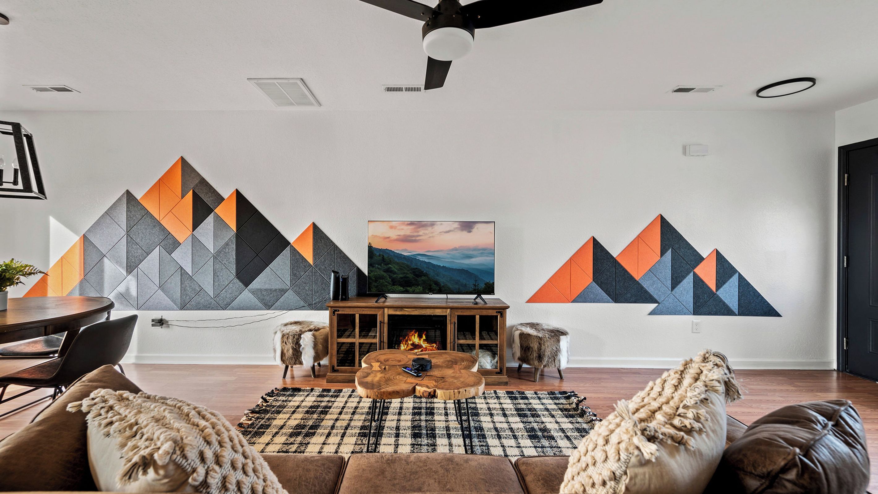 Un salon moderne doté d’une cheminée, d’un téléviseur et d’une grande œuvre d’art abstraite accrochée au mur.