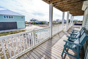A wooden deck with white railings, a pool, and beach houses in the background. - Hot Days, Cool Savings 20% OFF!!! 4BR/3.5BA Unobstructed Gulf Views (St. George Island)