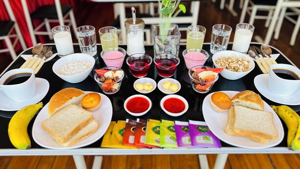 Desayuno con diversas opciones de comida y bebidas sobre una mesa.