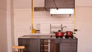 Una cocina compacta con una isla central, dos taburetes, una estufa y un fregadero.