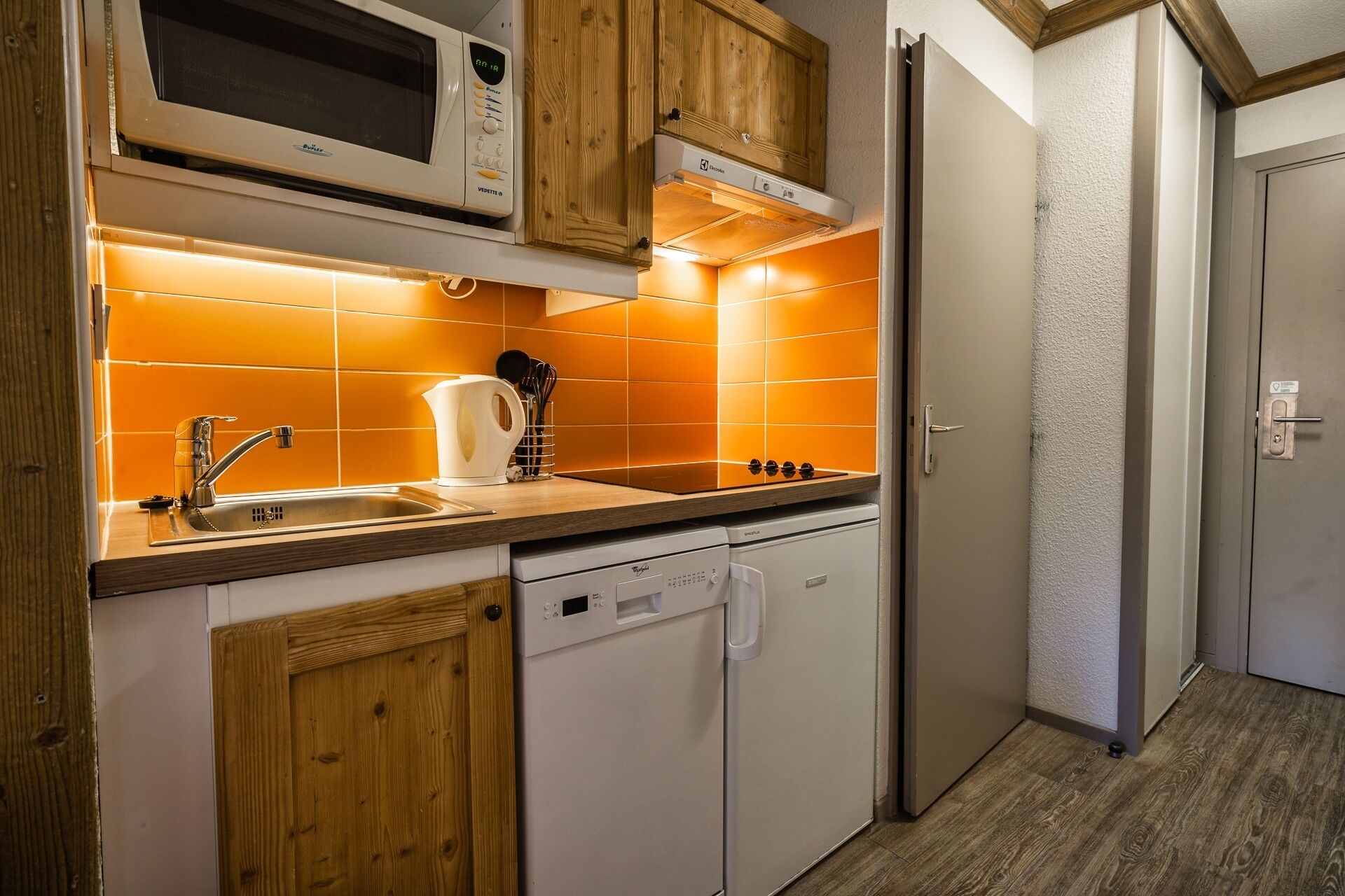 A kitchen with wooden cabinets, a microwave, a sink, and a dishwasher.
