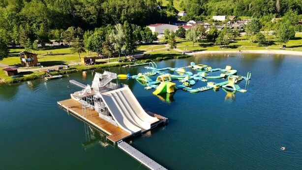 An aerial view of a water park with a large slide and inflatable play structures. - Le Coeur des Vosges -  Jacuzzi disponible toute l'année (Cornimont)