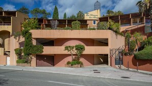 Un edificio de varios pisos con techo plano, un cartel que dice "Les Terrasses Du Morro" y una escalera que conduce a un nivel superior.